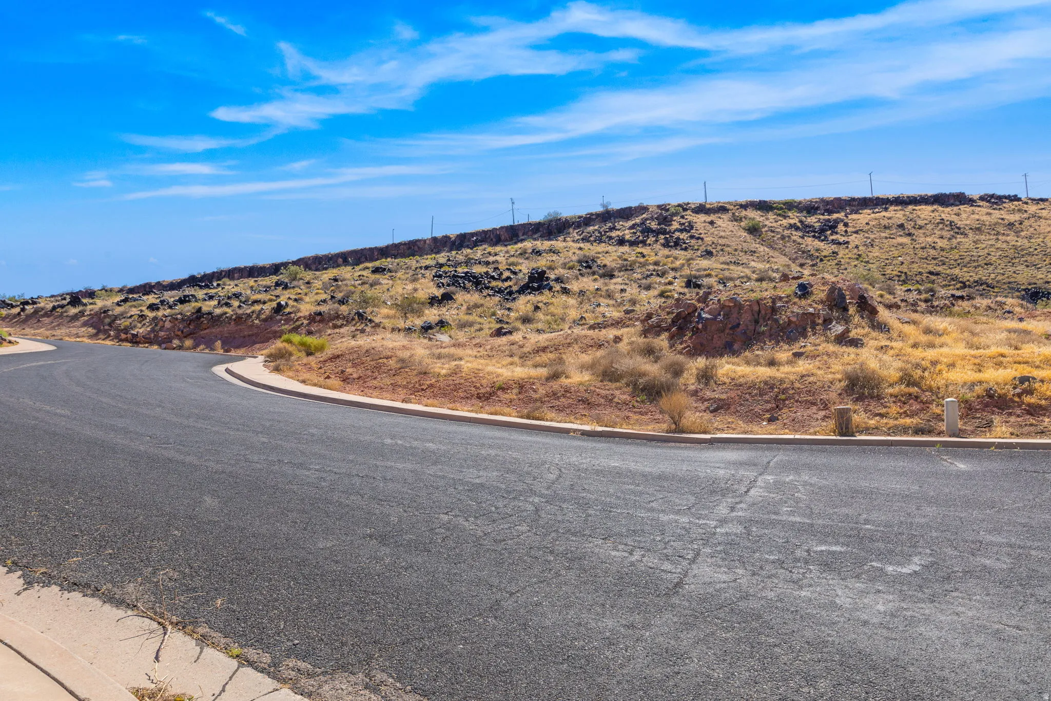 View of asphalt road featuring curbs