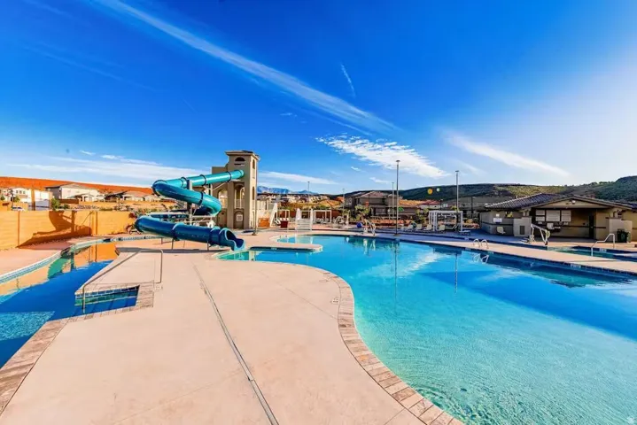Community pool featuring a patio area, a water slide, and a mountain view