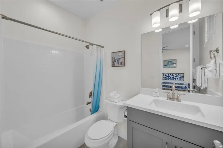 Bathroom featuring vanity, shower / bathtub combination with curtain, and ensuite bathroom