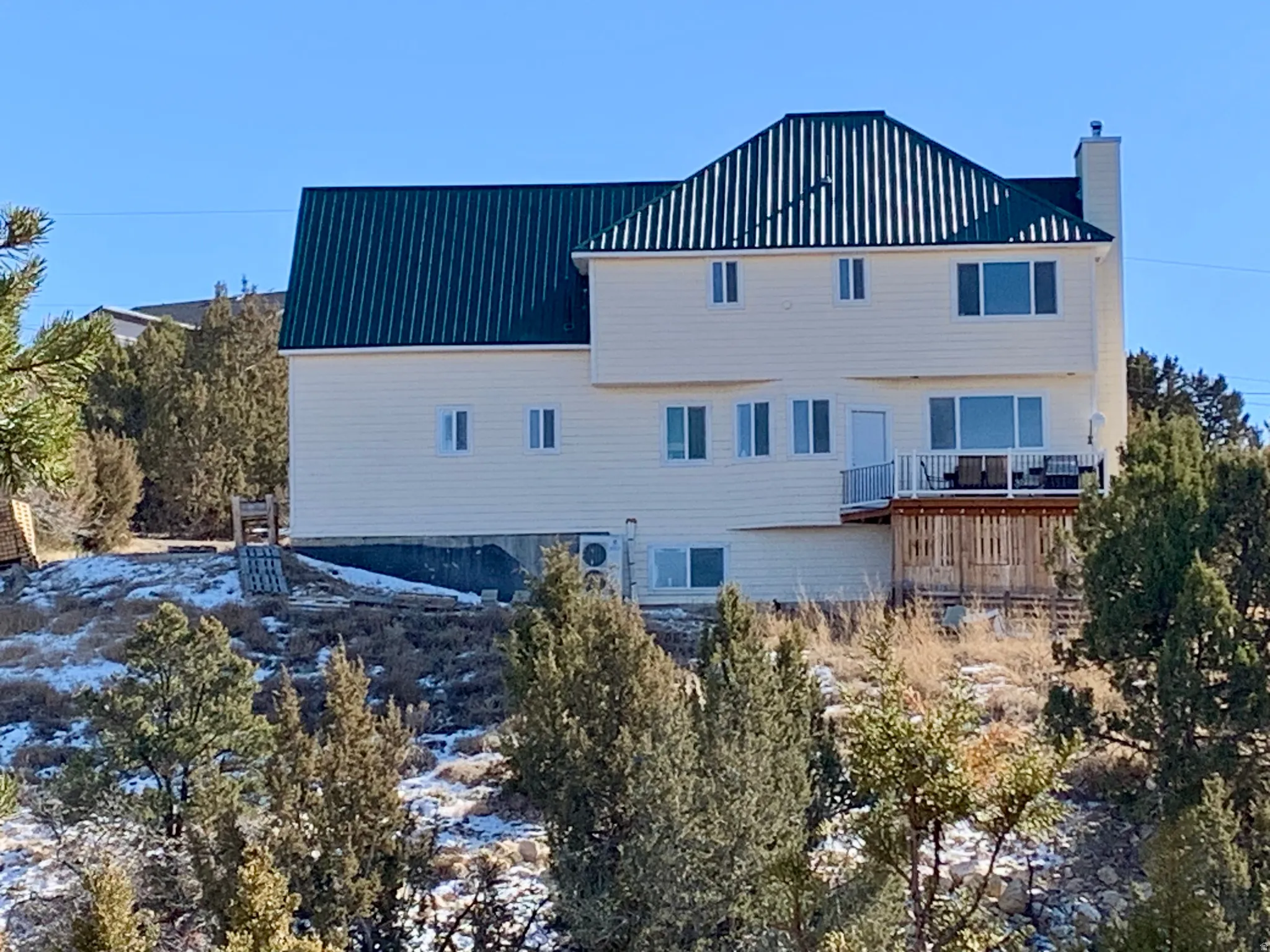 Back of property featuring a chimney and a metal roof