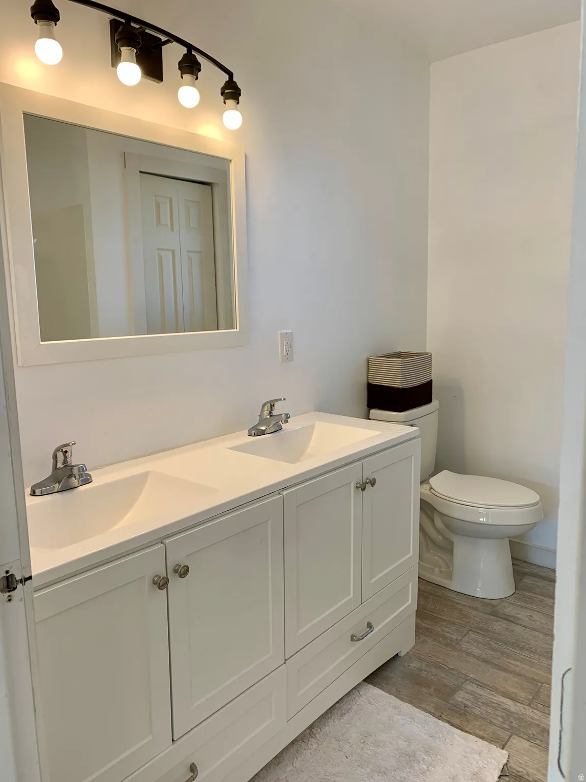 Bathroom featuring double vanity and light wood-style flooring