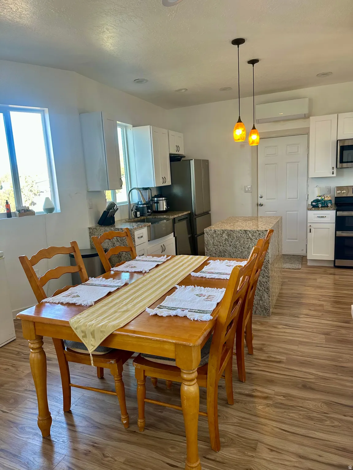 Dining room featuring dark wood-type flooring, a mini split for heating / cooling, and a textured ceiling