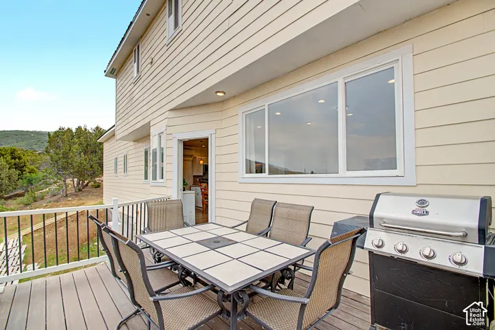 Expansive outdoor deck featuring wood-finish flooring and black metal railings