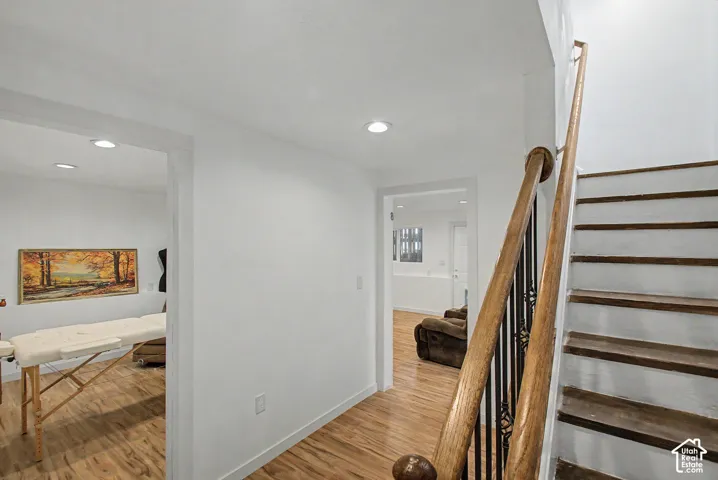 Staircase featuring wood treads, wood handrails, and wrought iron balusters
