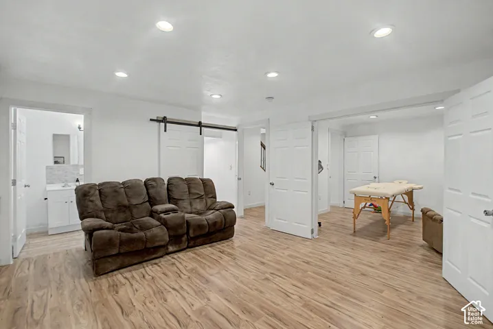 Expansive room featuring wood-finish flooring, white walls, and recessed lighting