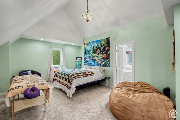 Room featuring a vaulted ceiling with an overhead chandelier and recessed lighting