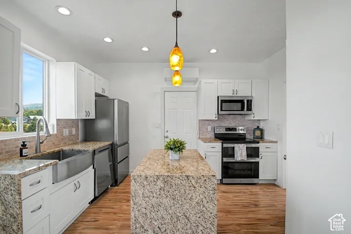 Contemporary kitchen featuring a central island with a granite-style countertop, complemented by matching perimeter countertops