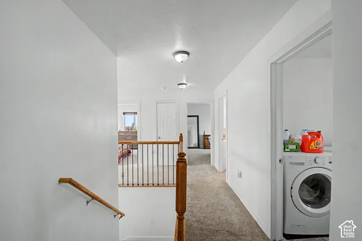 Upper-level hallway featuring neutral carpeting, white walls, and recessed lighting