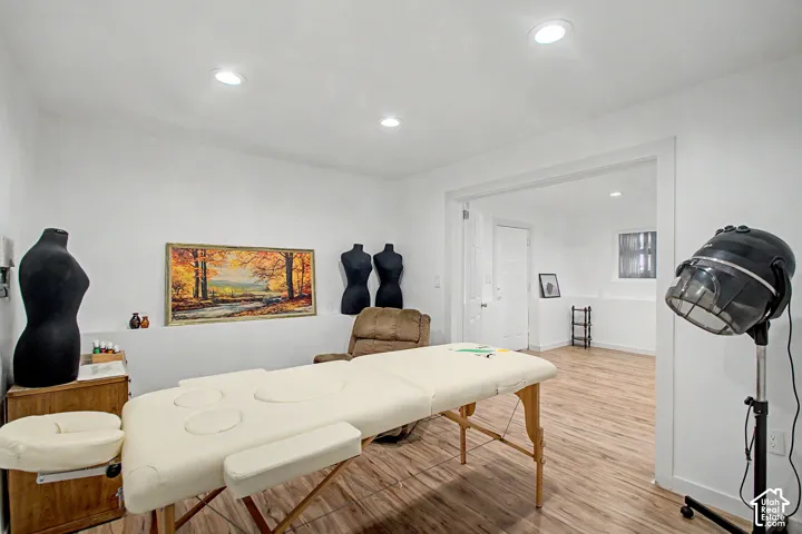 Spacious room featuring wood-finish flooring, recessed lighting, and a wide entryway to an additional room