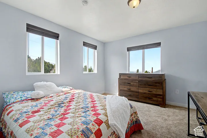 Spacious room featuring light blue walls and neutral-toned carpeting