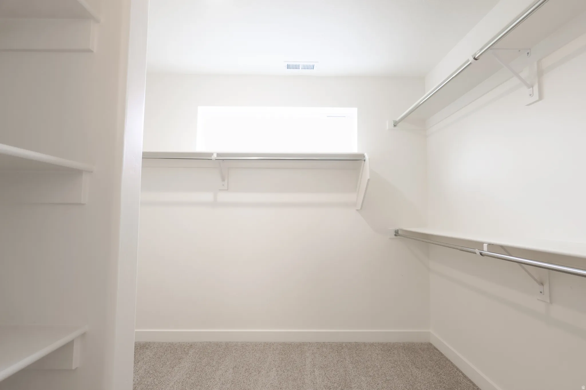 Walk in closet featuring light carpet