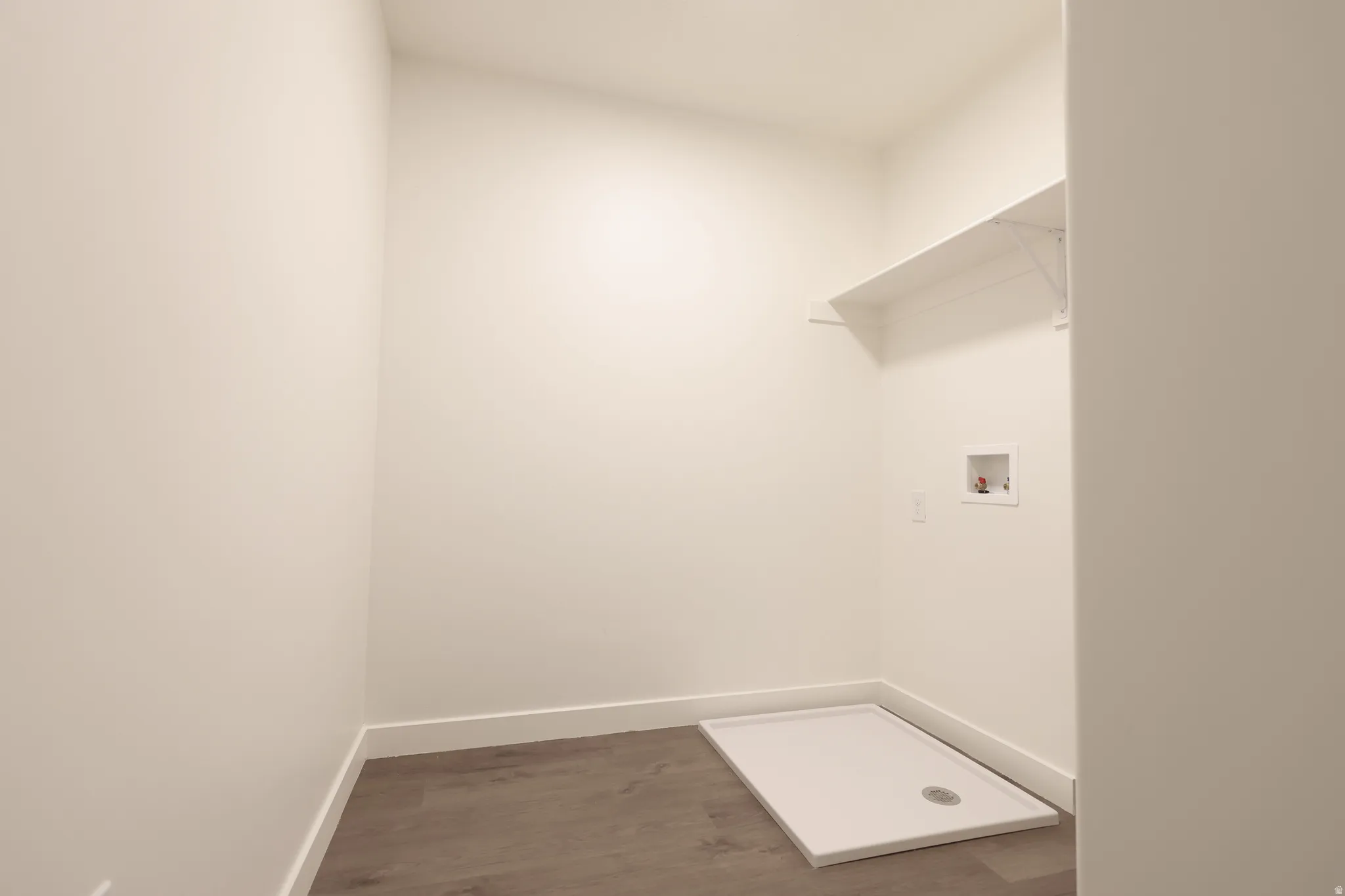 Laundry area featuring dark wood finished floors and hookup for a washing machine