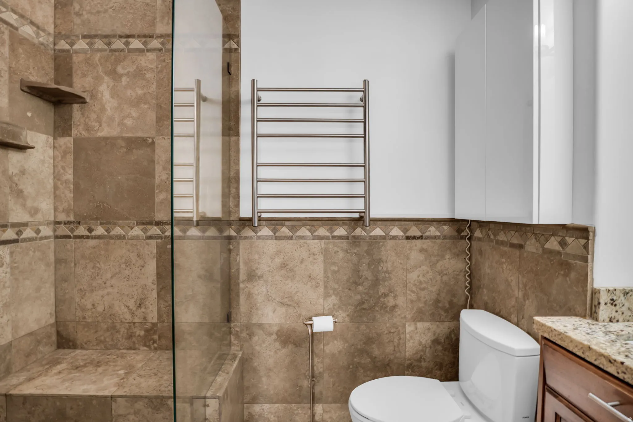 Full bathroom with vanity, radiator heating unit, a towel warming rack, and a walk in shower