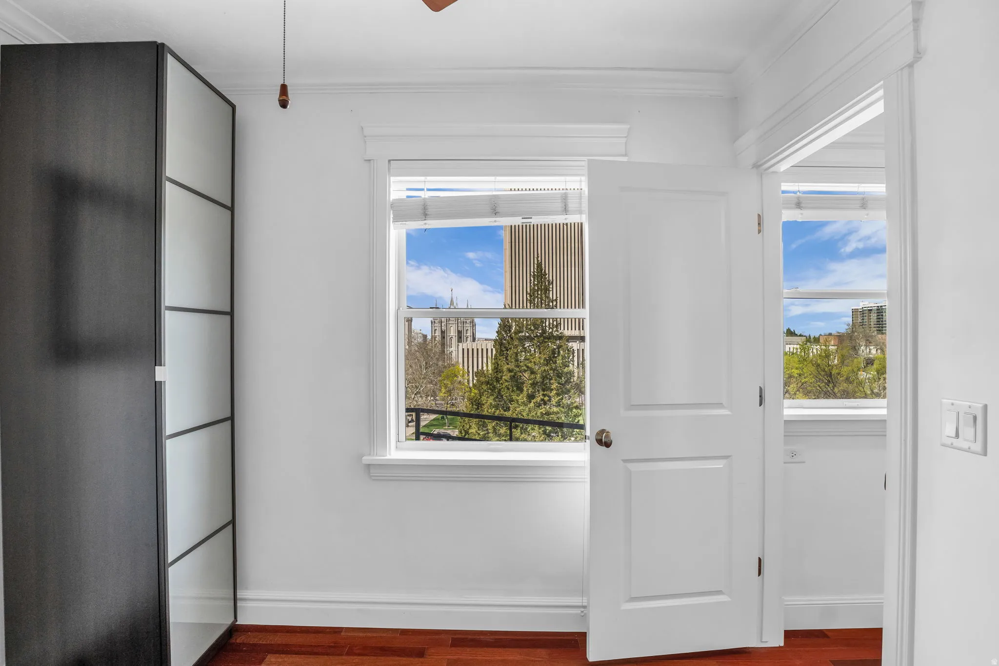 Entryway with wood finished floors, ornamental molding, and a ceiling fan