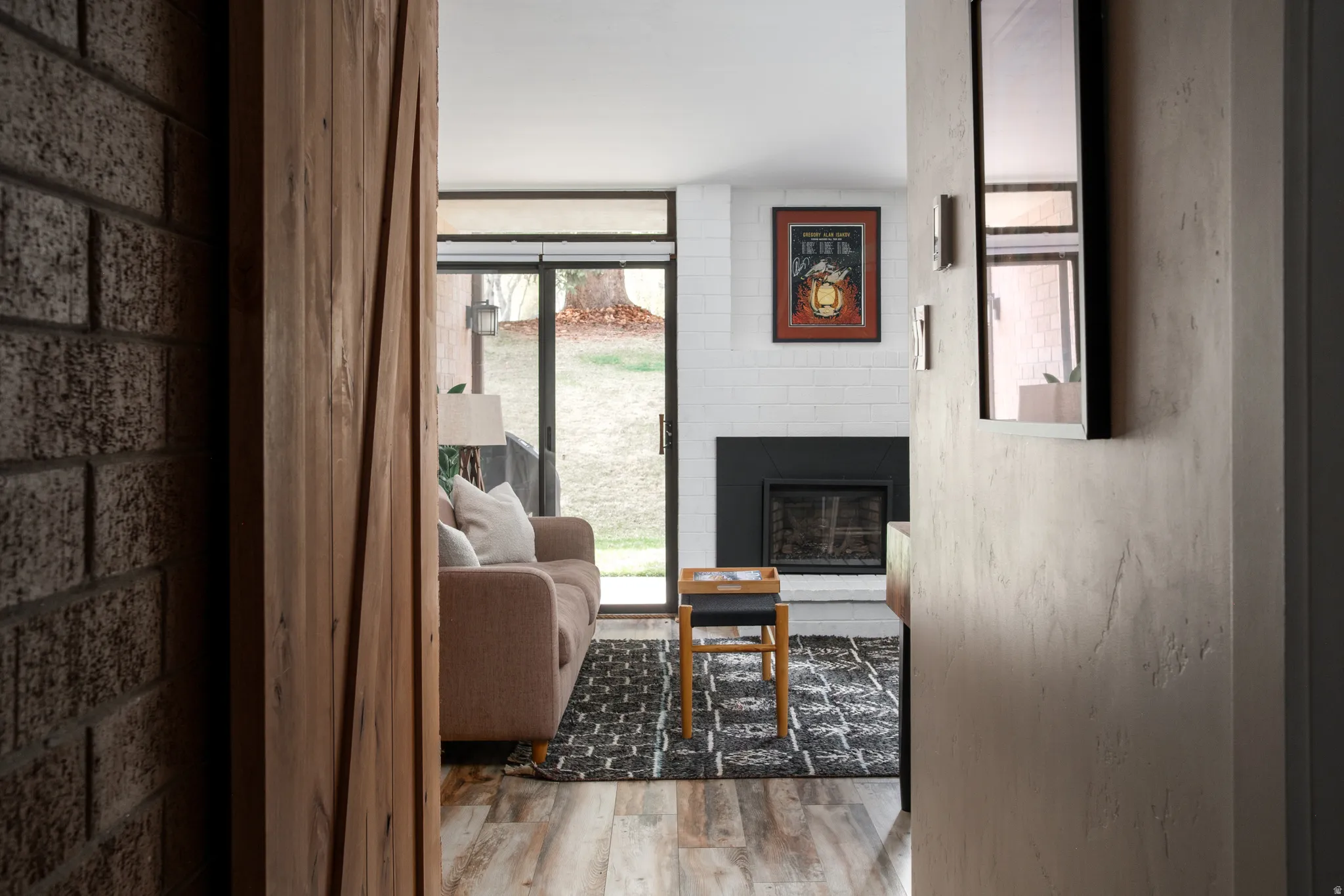 Living room with a large fireplace and light wood-style floors