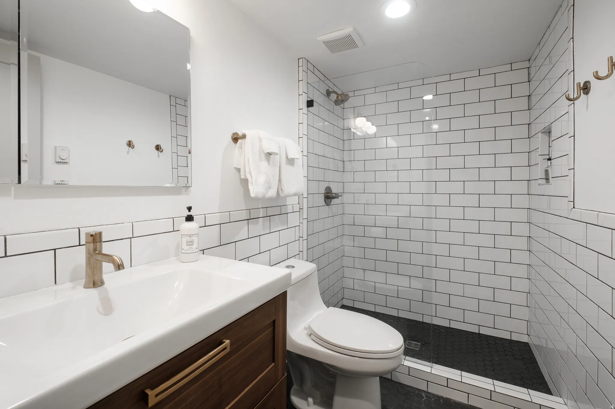 Full bathroom featuring vanity, tile walls, and a stall shower