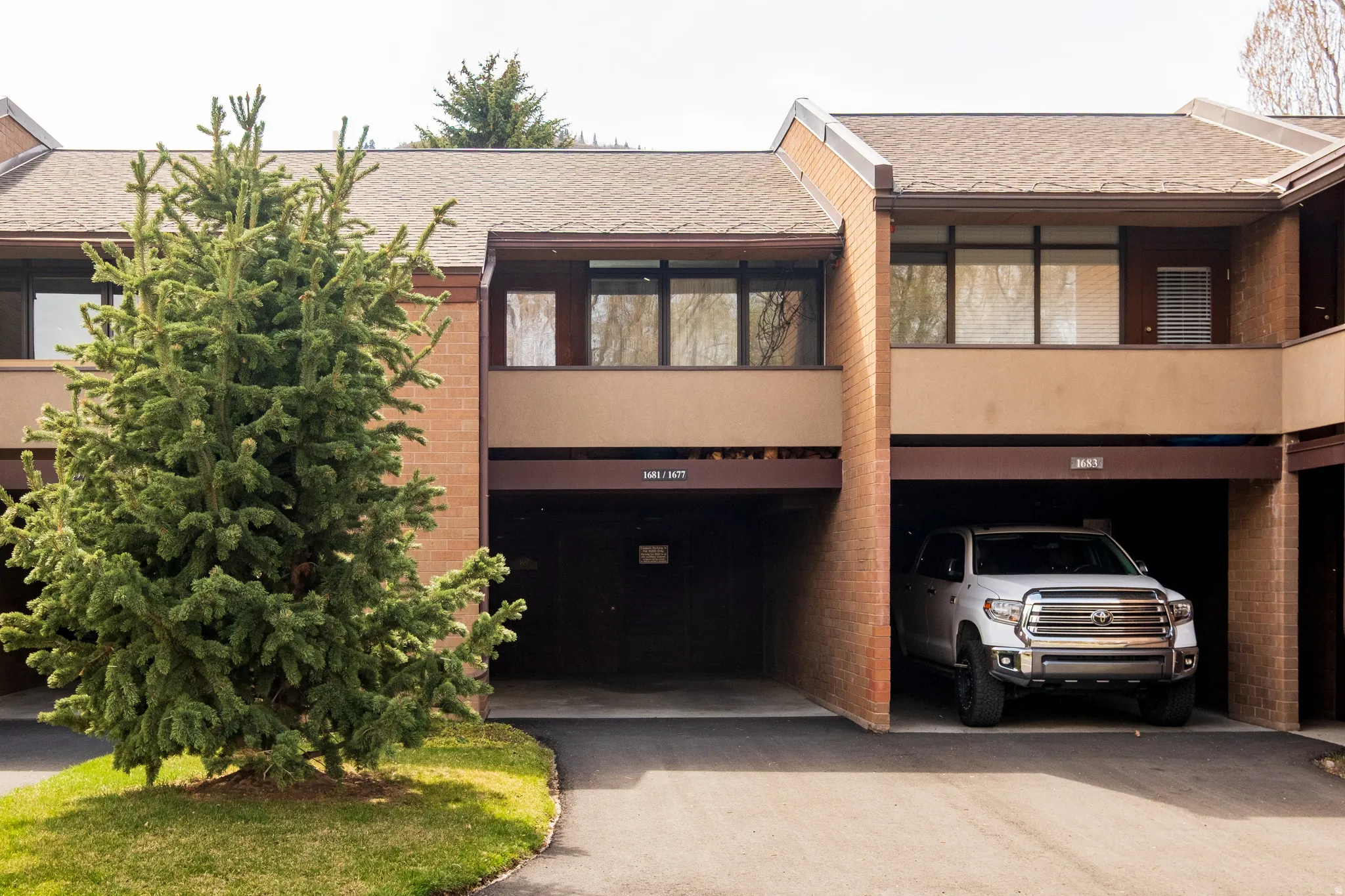 View of front of property featuring roof with shingles and brick siding