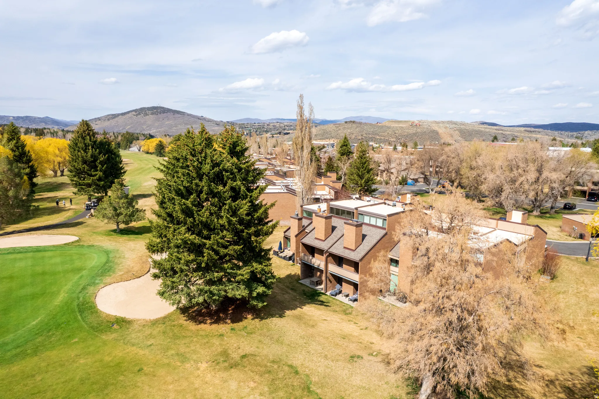 Aerial view of a mountainous background and a local golf course