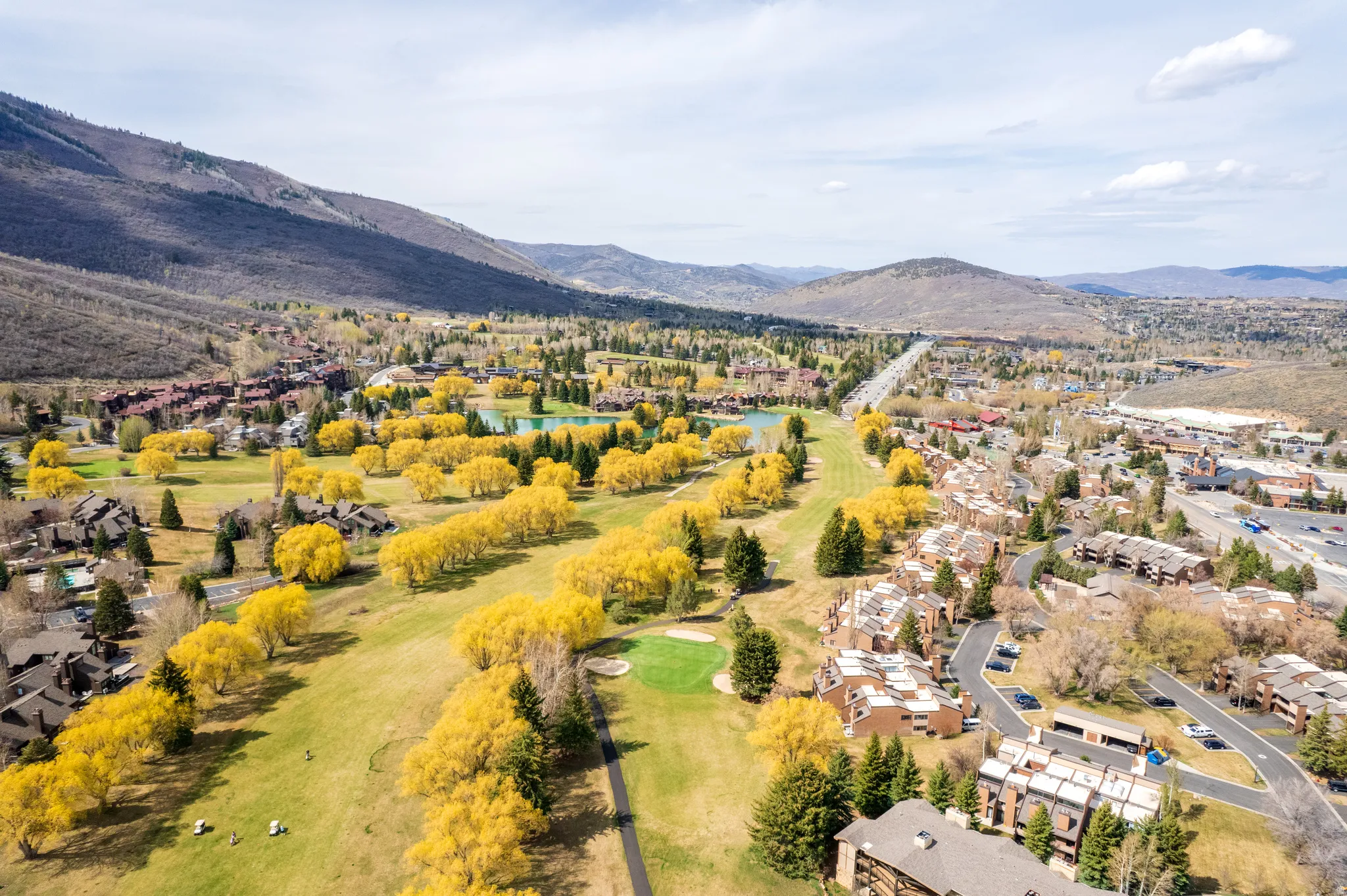 Aerial view of residential area featuring a local golf course and a water and mountain view
