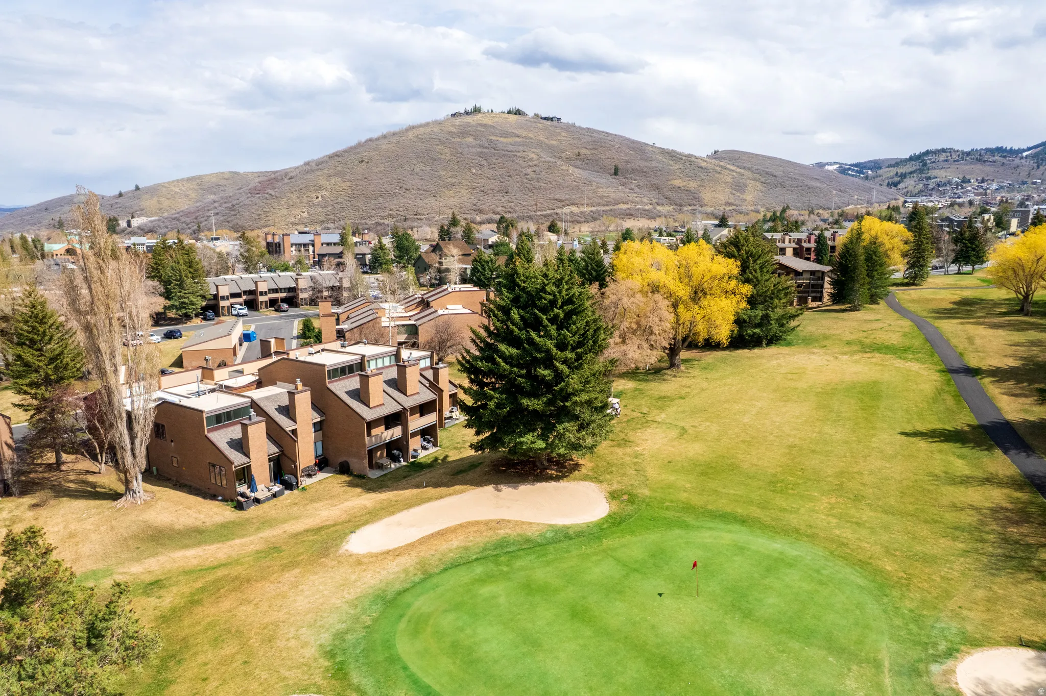Drone / aerial view of a local golf course and a mountainous background