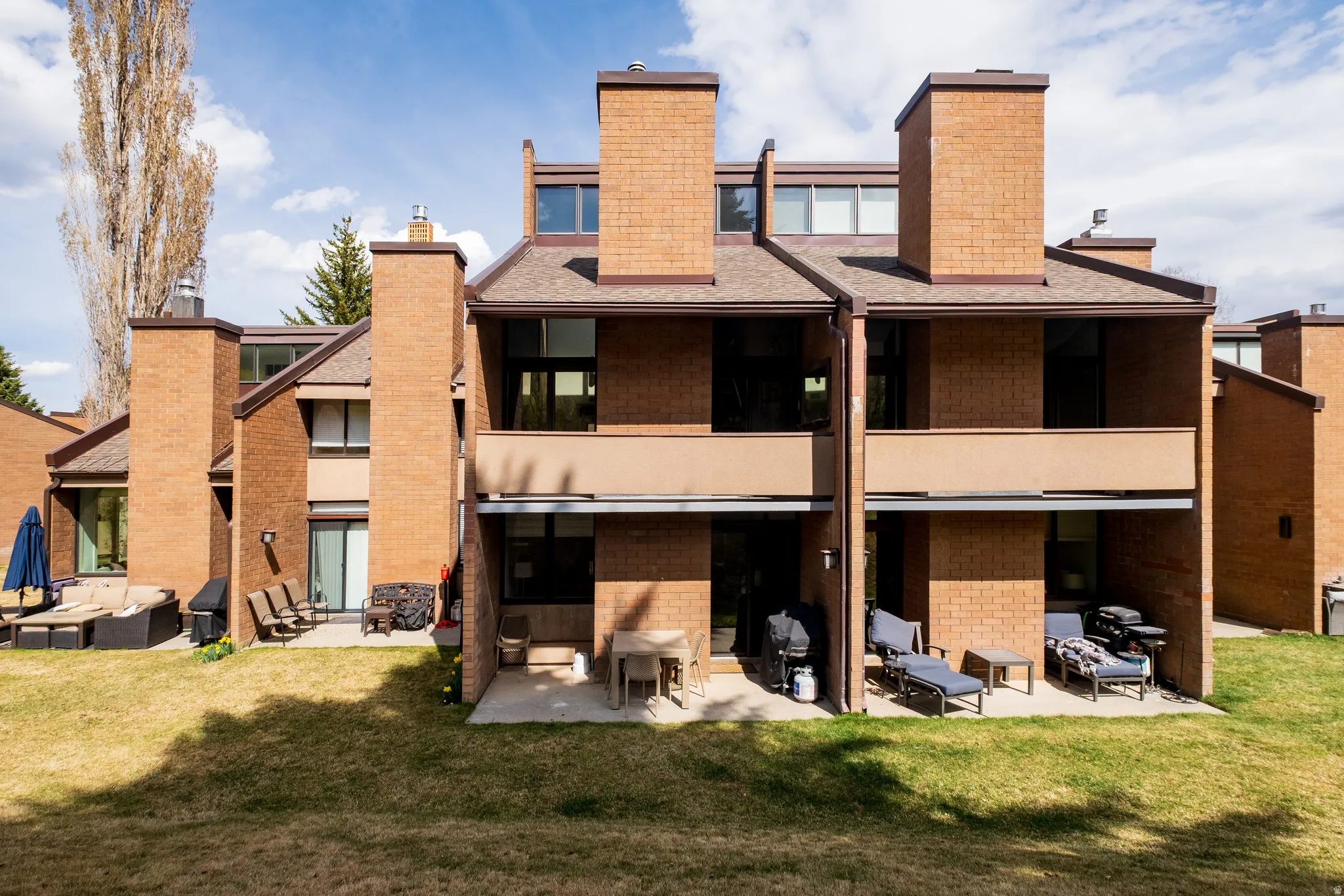 Back of house with a patio, a chimney, and a yard
