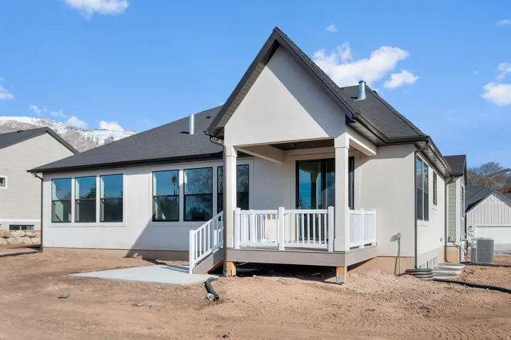 Back of house featuring a patio, a shingled roof, a deck with mountain view, and stucco siding