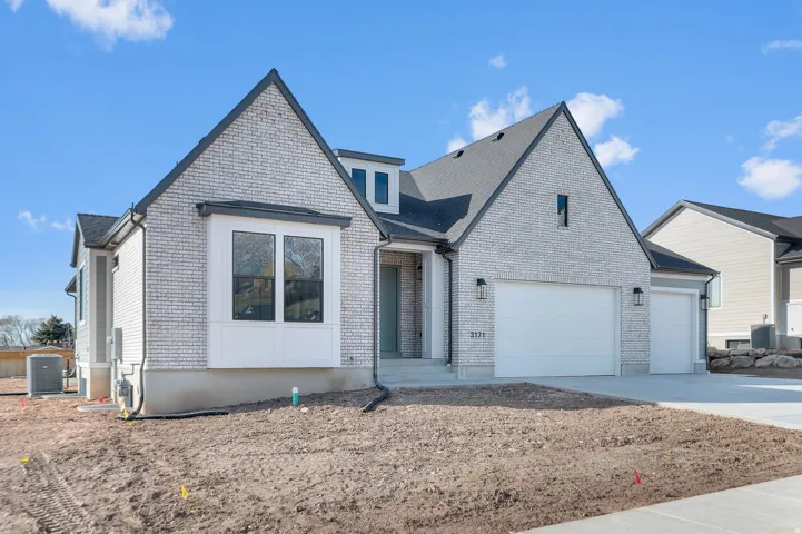 View of front of house featuring brick siding, concrete driveway, and an attached garage