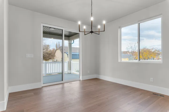 Unfurnished dining area featuring suspended lighting and dark wood finished floors