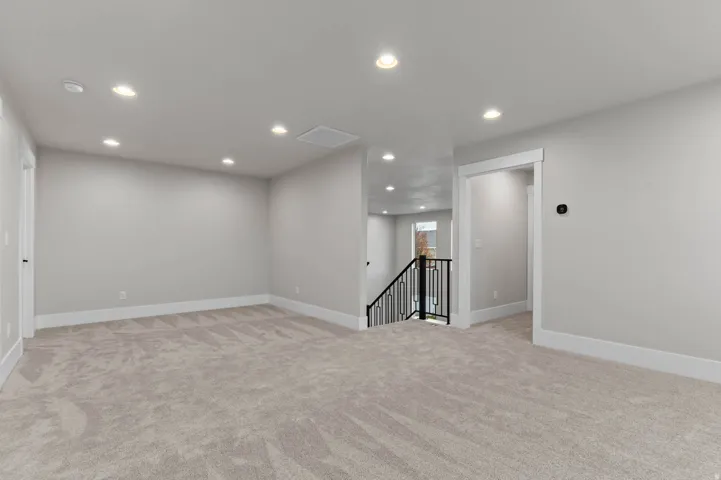 Empty room with recessed lighting and light colored carpet