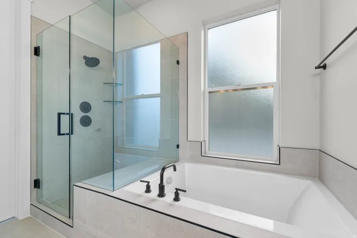 Full bath featuring a stall shower and a bath