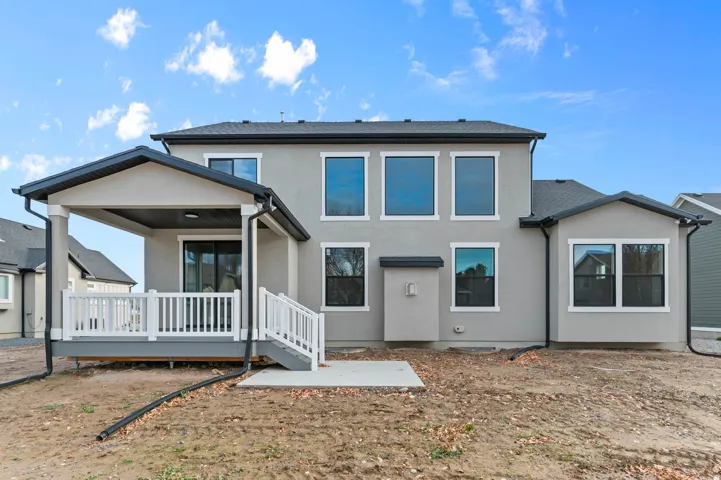 Rear view of house featuring a patio, a wooden deck, and stucco siding