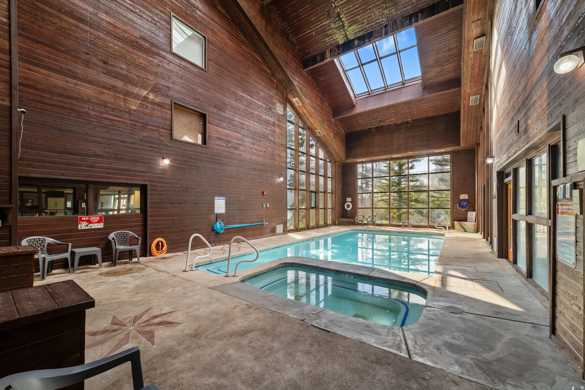 Indoor community pool featuring a skylight