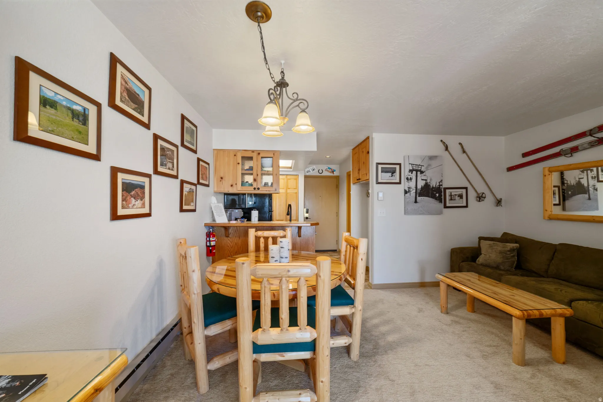 Dining area featuring light colored carpet, a baseboard heating unit, and a chandelier