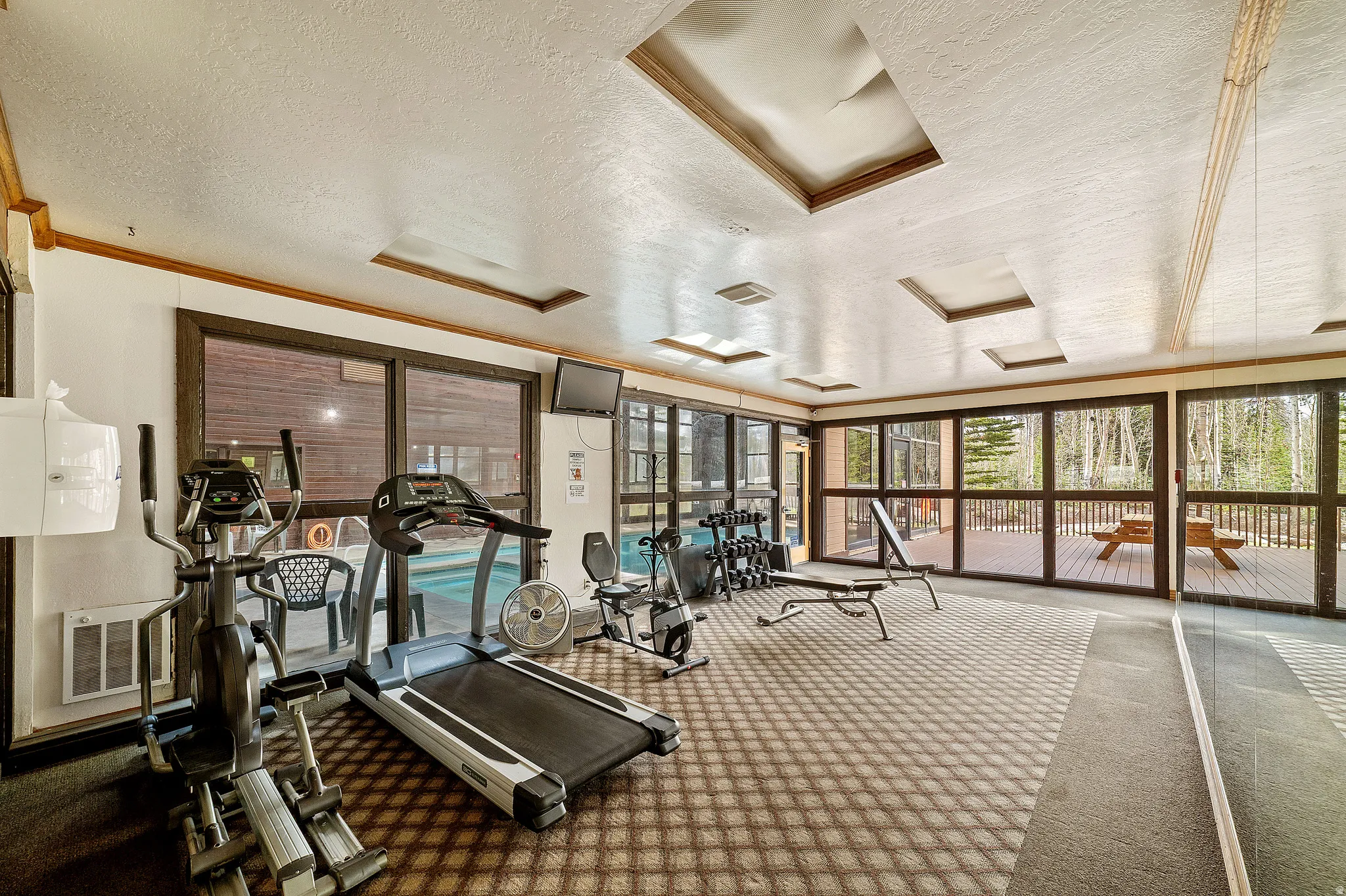 Workout area featuring a textured ceiling and crown molding