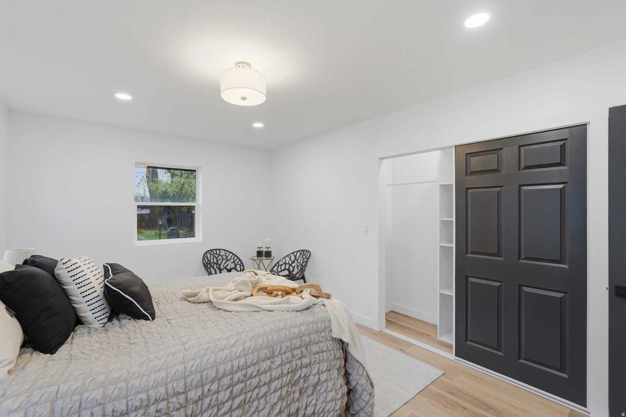 Bedroom featuring light wood-style floors, recessed lighting, and a closet