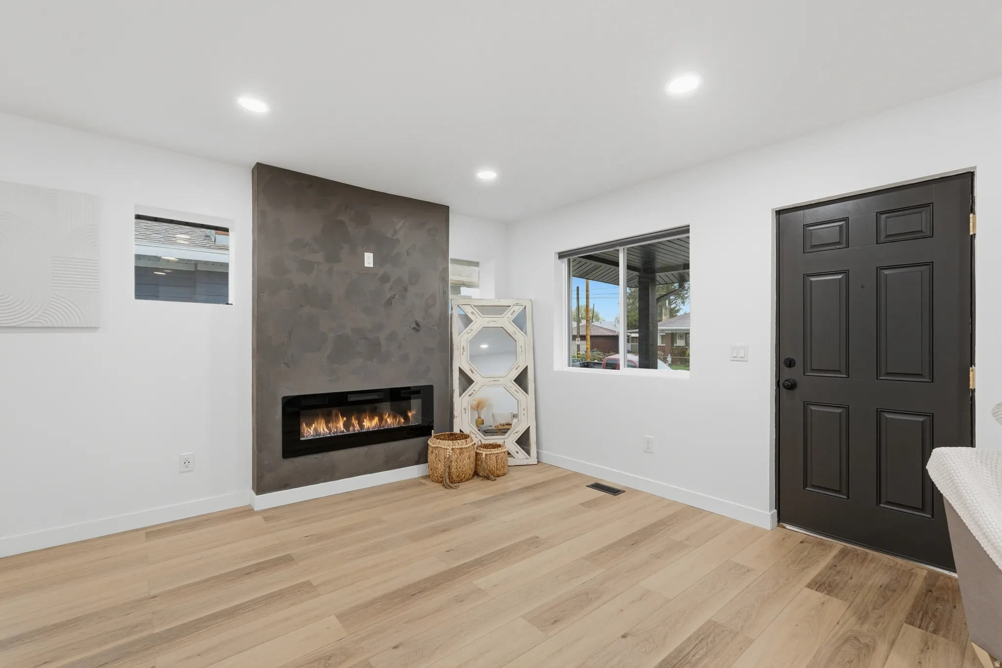 Unfurnished living room with light wood-type flooring, a fireplace, and recessed lighting