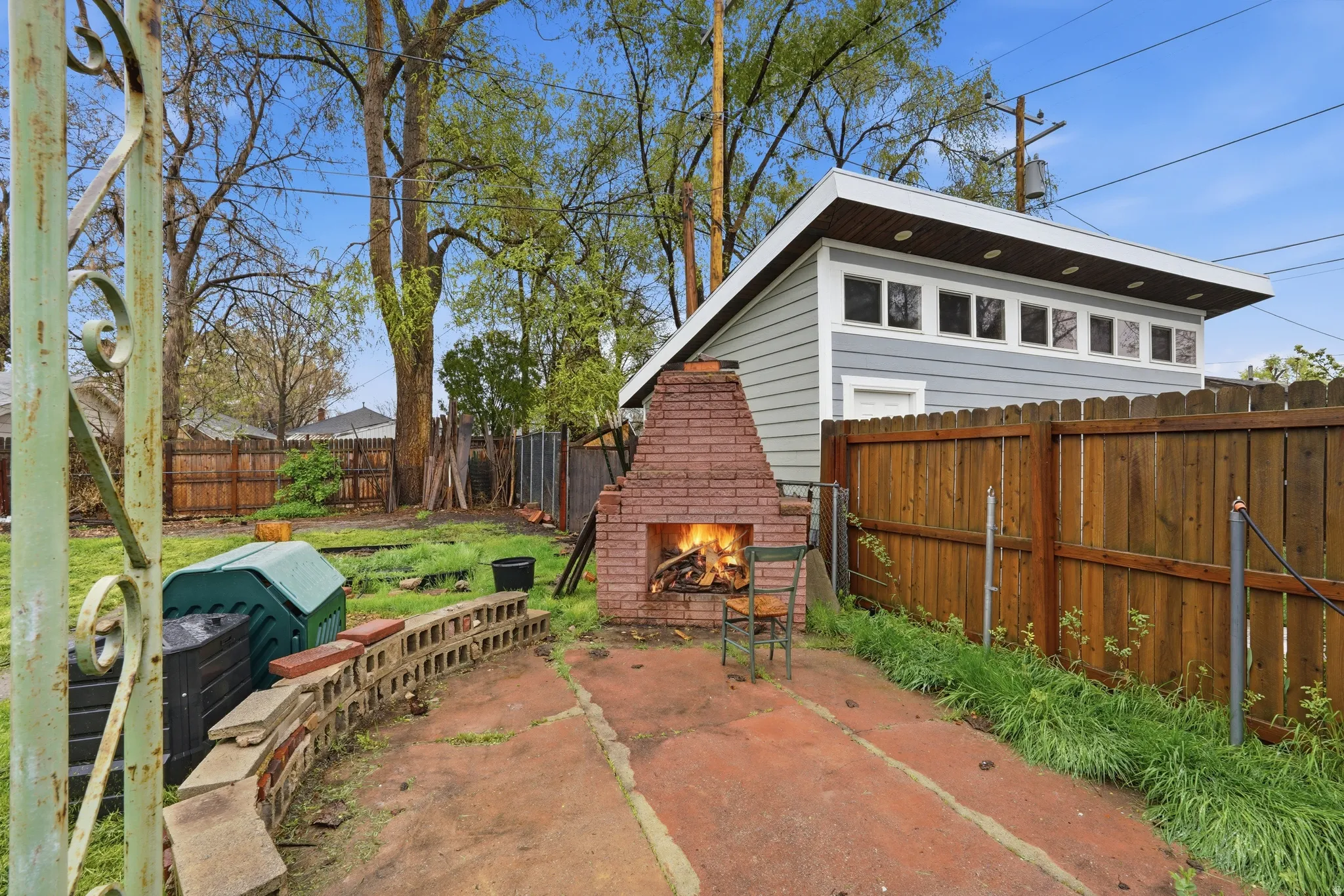Fenced backyard with an outdoor brick fireplace