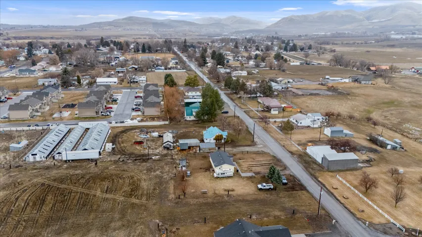 Aerial view of property and surrounding area with mountains and nearby suburban area