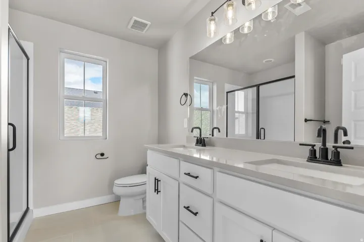 Full bathroom with a shower stall and double vanity