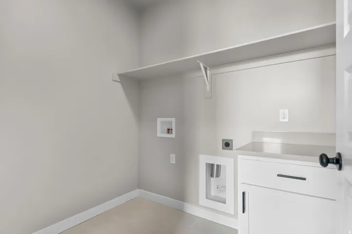 Laundry area featuring washer hookup, electric dryer hookup, and cabinet space