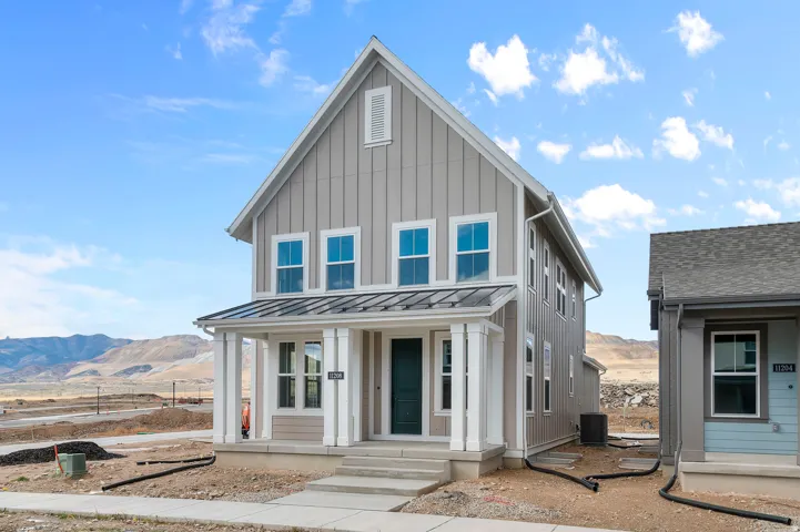 View of front of home with a standing seam roof, a mountain view, board and batten siding, and a porch