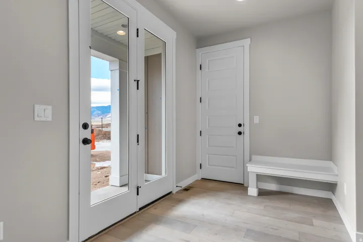 Foyer entrance with light wood-style flooring and baseboards