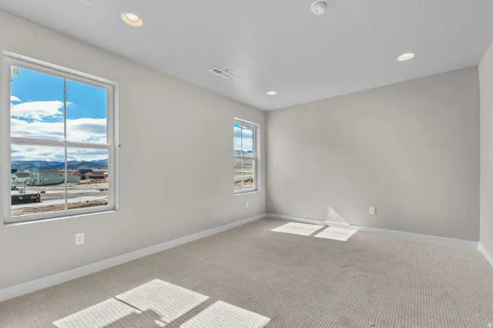 Empty room with light colored carpet, a mountain view, and recessed lighting