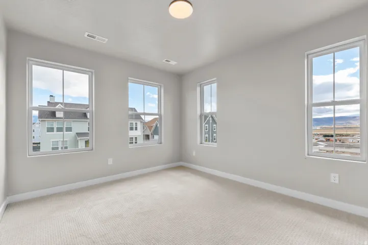 Unfurnished room with baseboards and light colored carpet