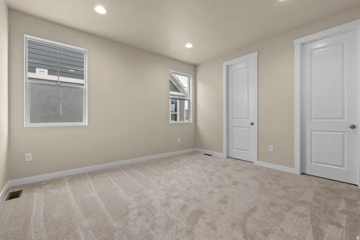 Unfurnished bedroom featuring light colored carpet and recessed lighting