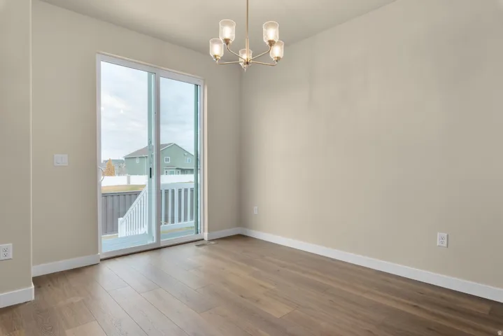 Spare room featuring hanging lights and light wood-style floors