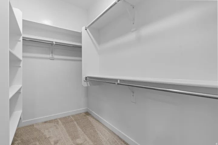 Walk in closet featuring light carpet