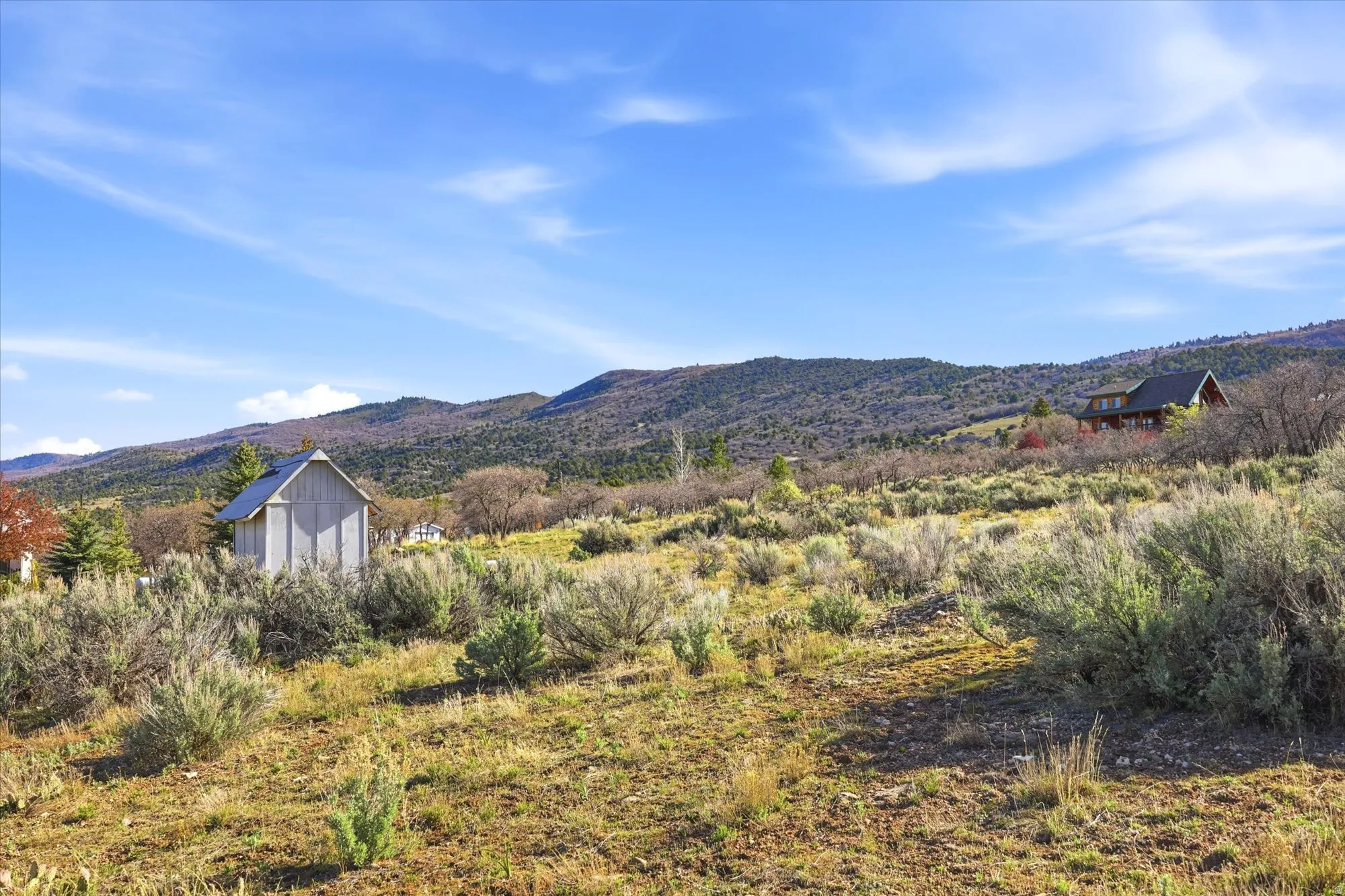 Expansive terrain with natural vegetation, featuring distant mountain ranges and a clear sky