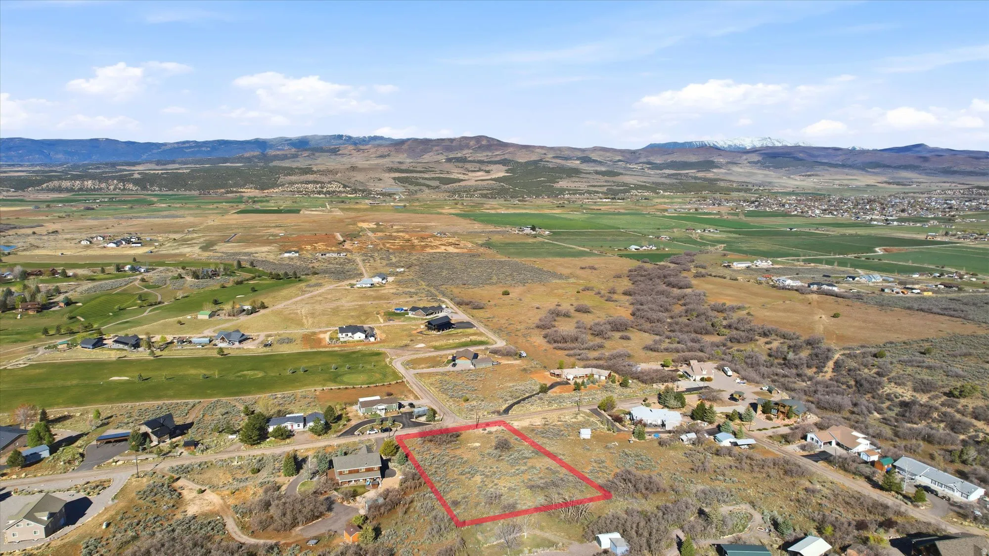 Expansive undeveloped land parcel framed by a red outline, situated in a high-elevation setting
