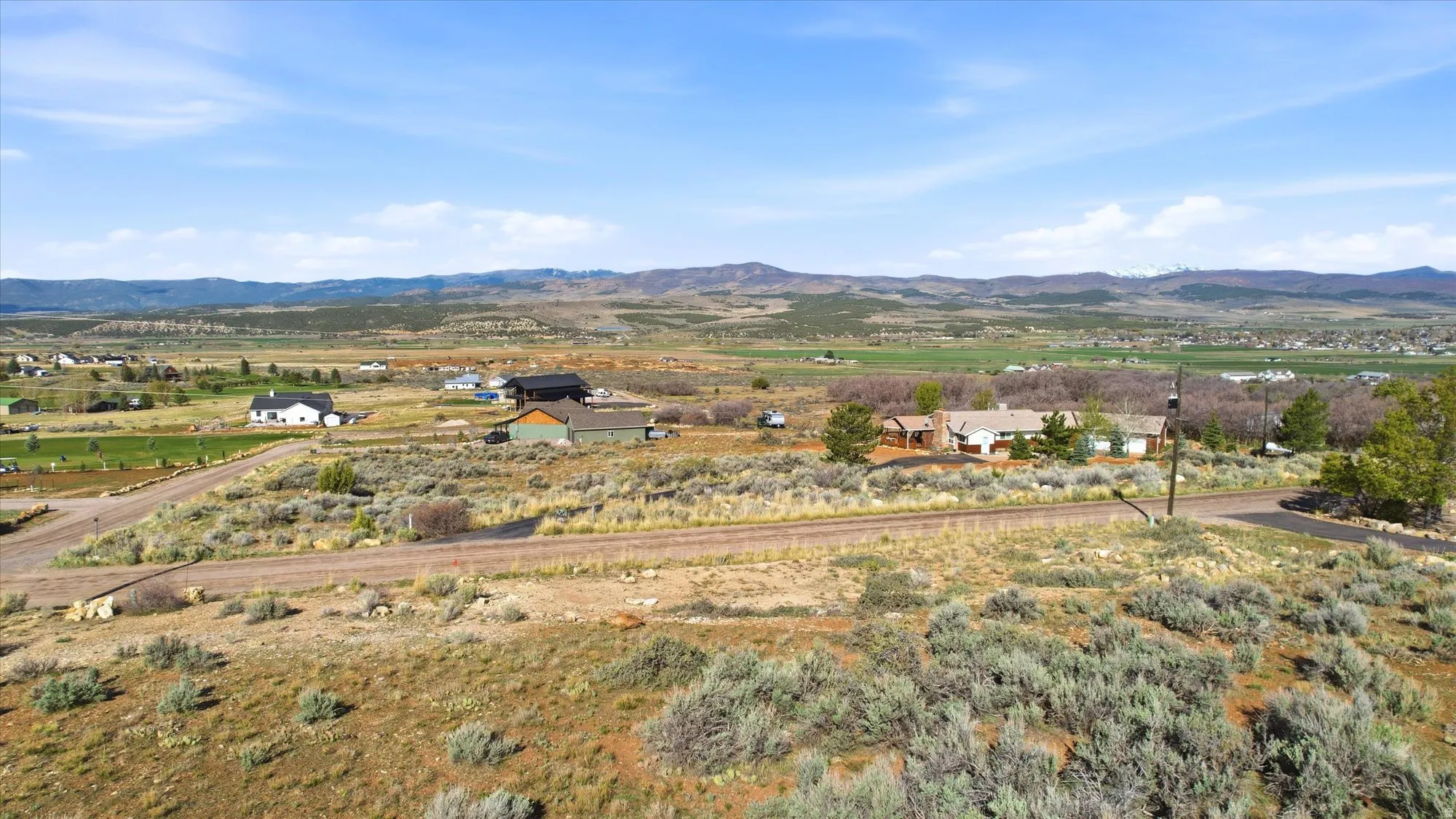 Expansive rural landscape featuring a distant mountain range and multiple homesites